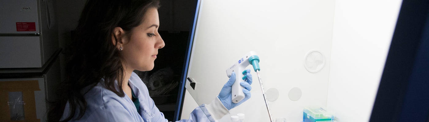 Researcher squeezing pipette into tube