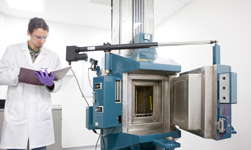 Researcher smiling with hands in radioactive material machine